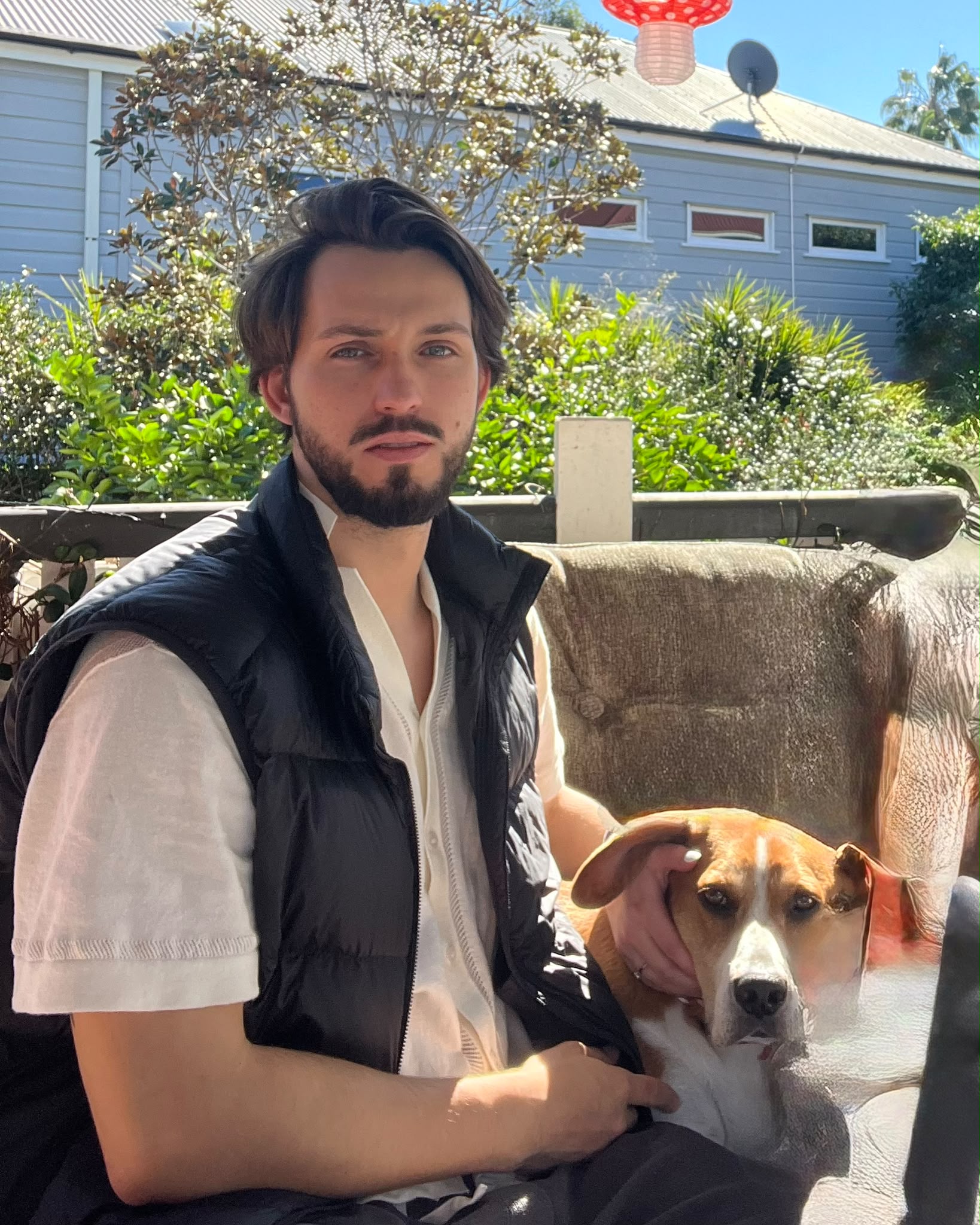 Sitting outdoors beside a brown and white dog